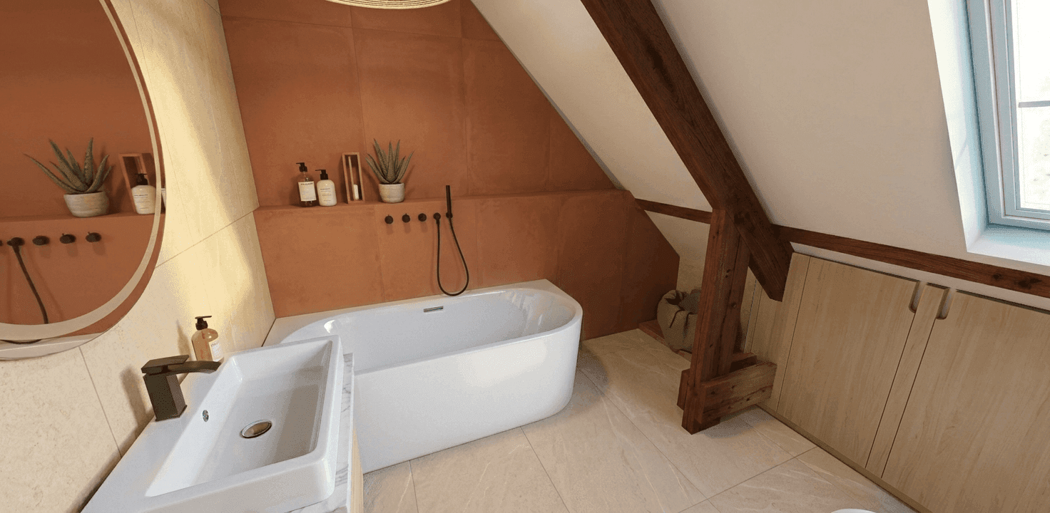 Salle de bain sous combles avec baignoire et carrelage terracotta